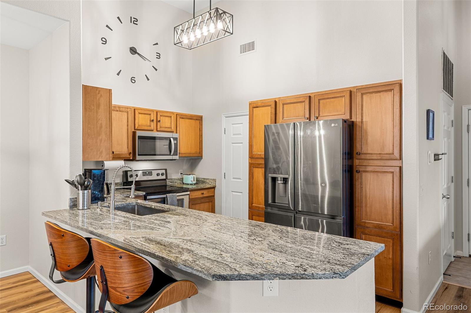 8073 West 51st Place, Unit 303 Arvada, CO 80002 - Photo 12 of 48 a kitchen with stainless steel appliances granite countertop a sink refrigerator stove and microwave
