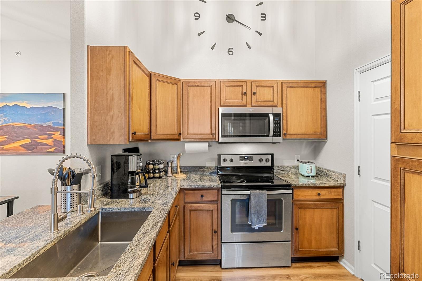 8073 West 51st Place, Unit 303 Arvada, CO 80002 - Photo 15 of 48 a kitchen with a stove a sink and a microwave