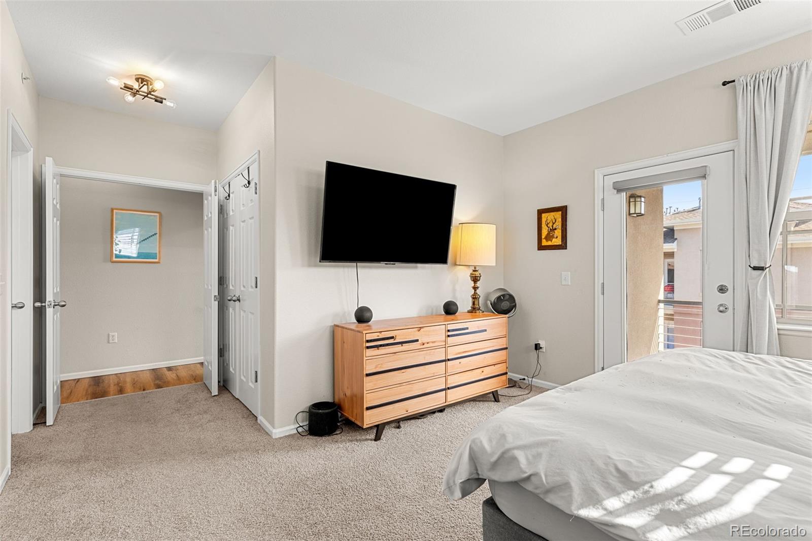 8073 West 51st Place, Unit 303 Arvada, CO 80002 - Photo 27 of 48 a spacious bedroom with a bed and a flat screen tv