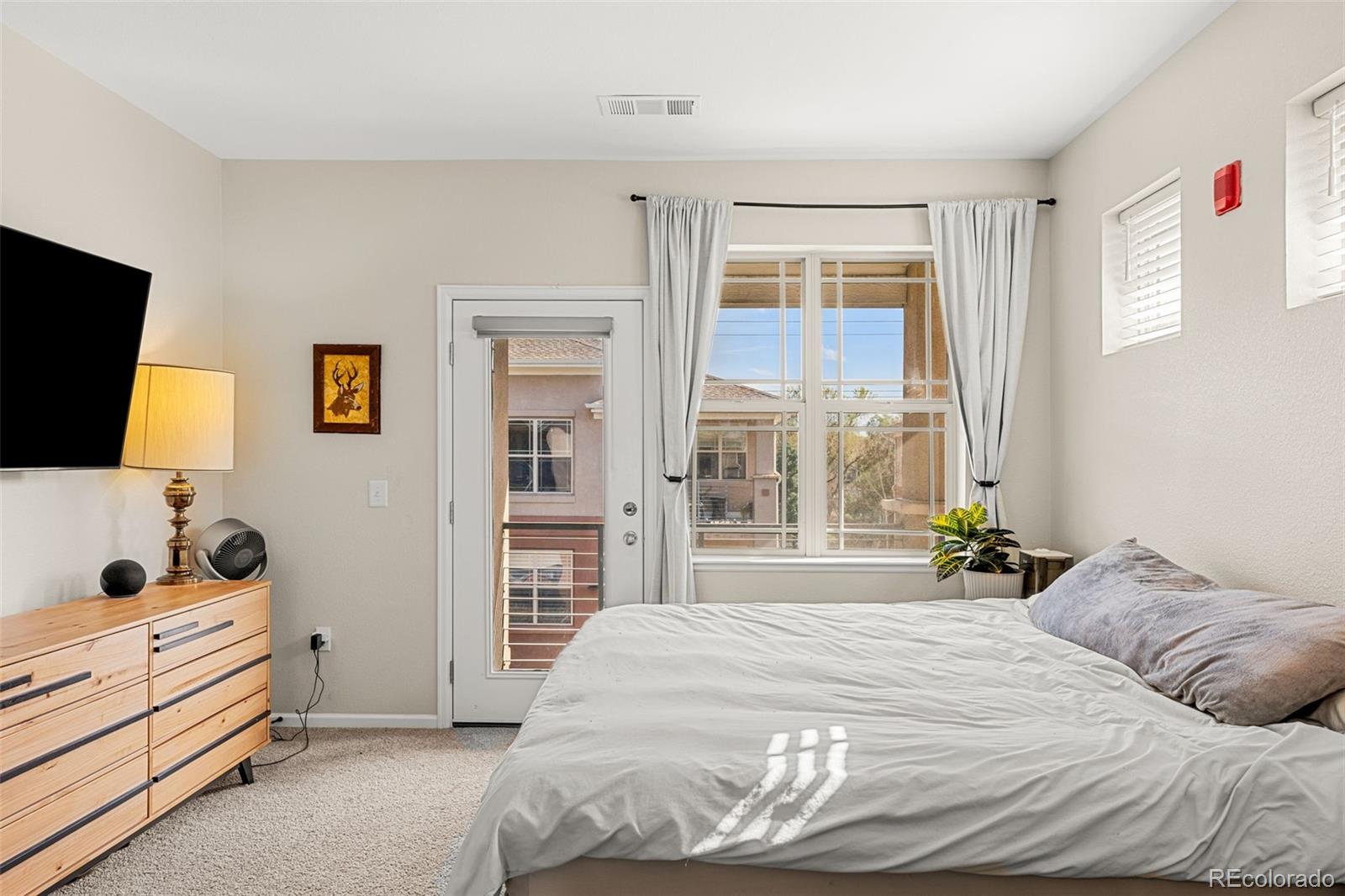 8073 West 51st Place, Unit 303 Arvada, CO 80002 - Photo 28 of 48 a bedroom with a bed and flat screen tv