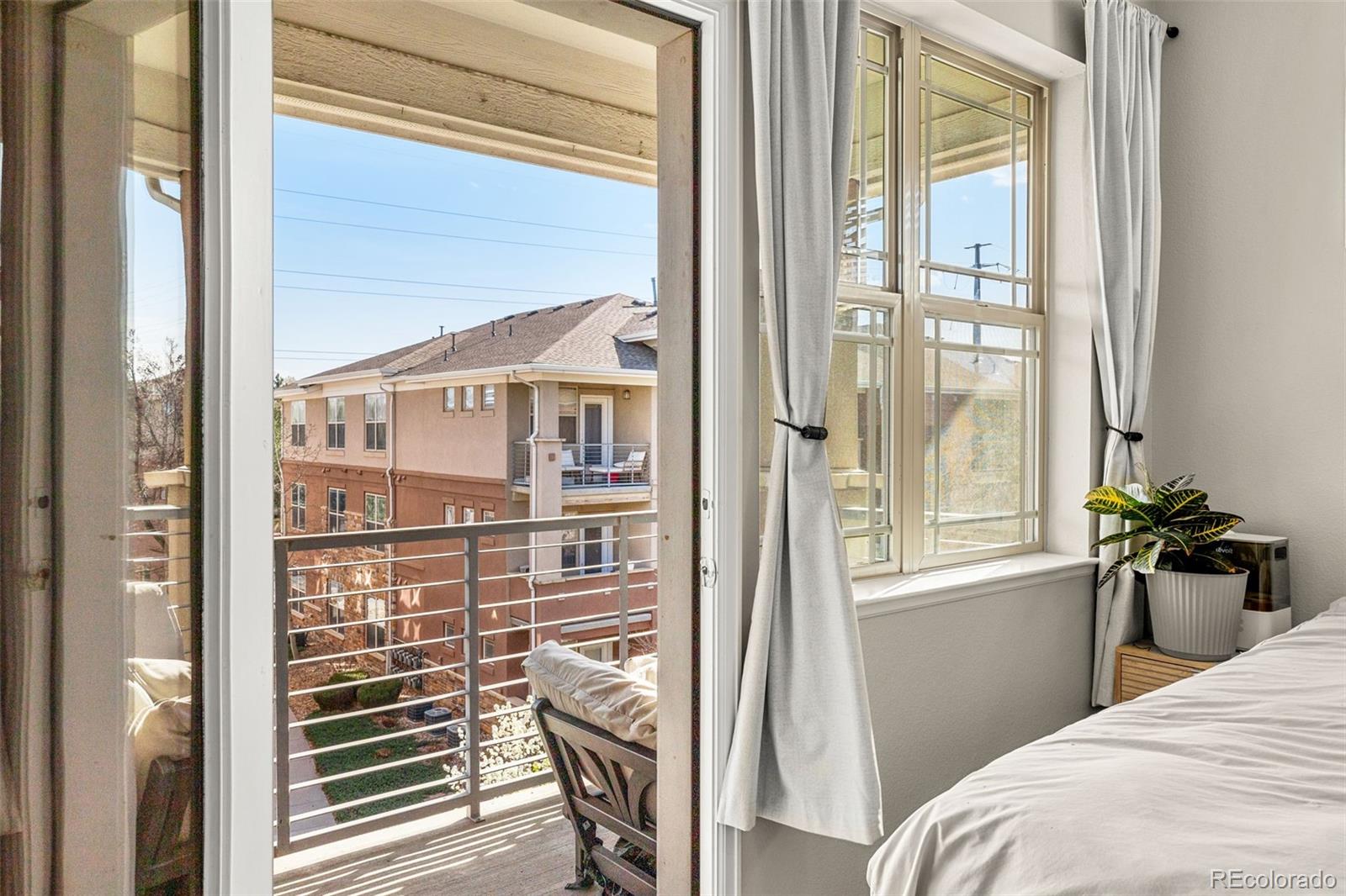 8073 West 51st Place, Unit 303 Arvada, CO 80002 - Photo 32 of 48 a bedroom with a balcony a bed and a window