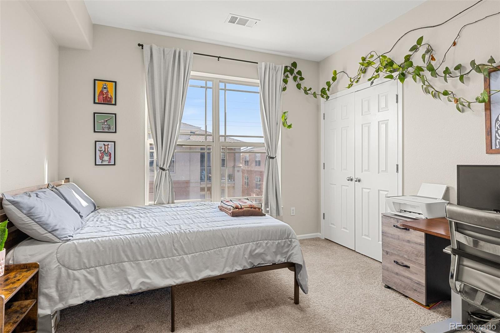 8073 West 51st Place, Unit 303 Arvada, CO 80002 - Photo 34 of 48 a bedroom with a bed table and a potted plant