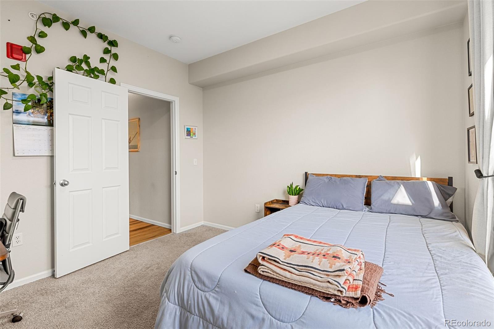 8073 West 51st Place, Unit 303 Arvada, CO 80002 - Photo 35 of 48 a bed room with a bed and a potted plant