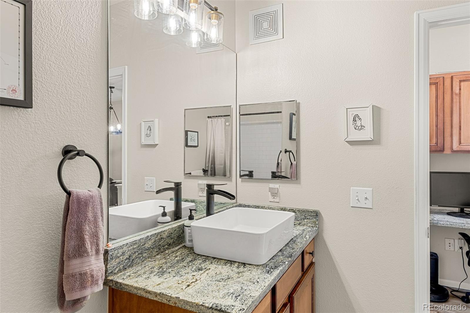 8073 West 51st Place, Unit 303 Arvada, CO 80002 - Photo 37 of 48 a bathroom with a granite countertop sink and a mirror
