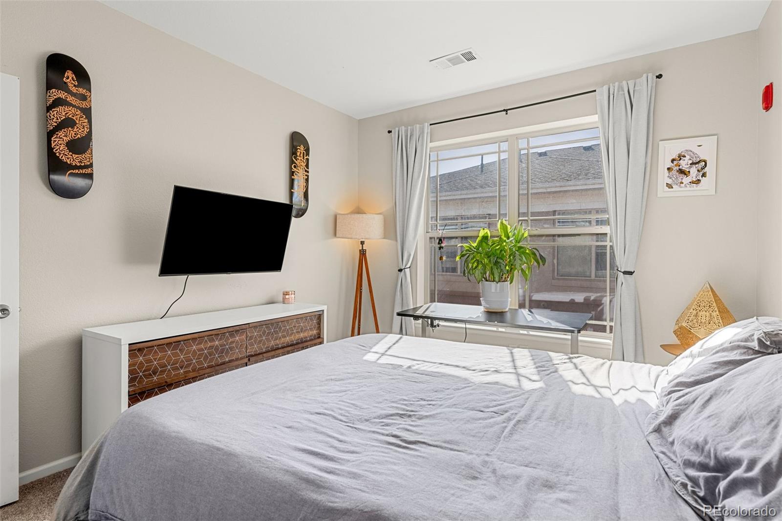 8073 West 51st Place, Unit 303 Arvada, CO 80002 - Photo 39 of 48 a bedroom with a bed and a flat screen tv