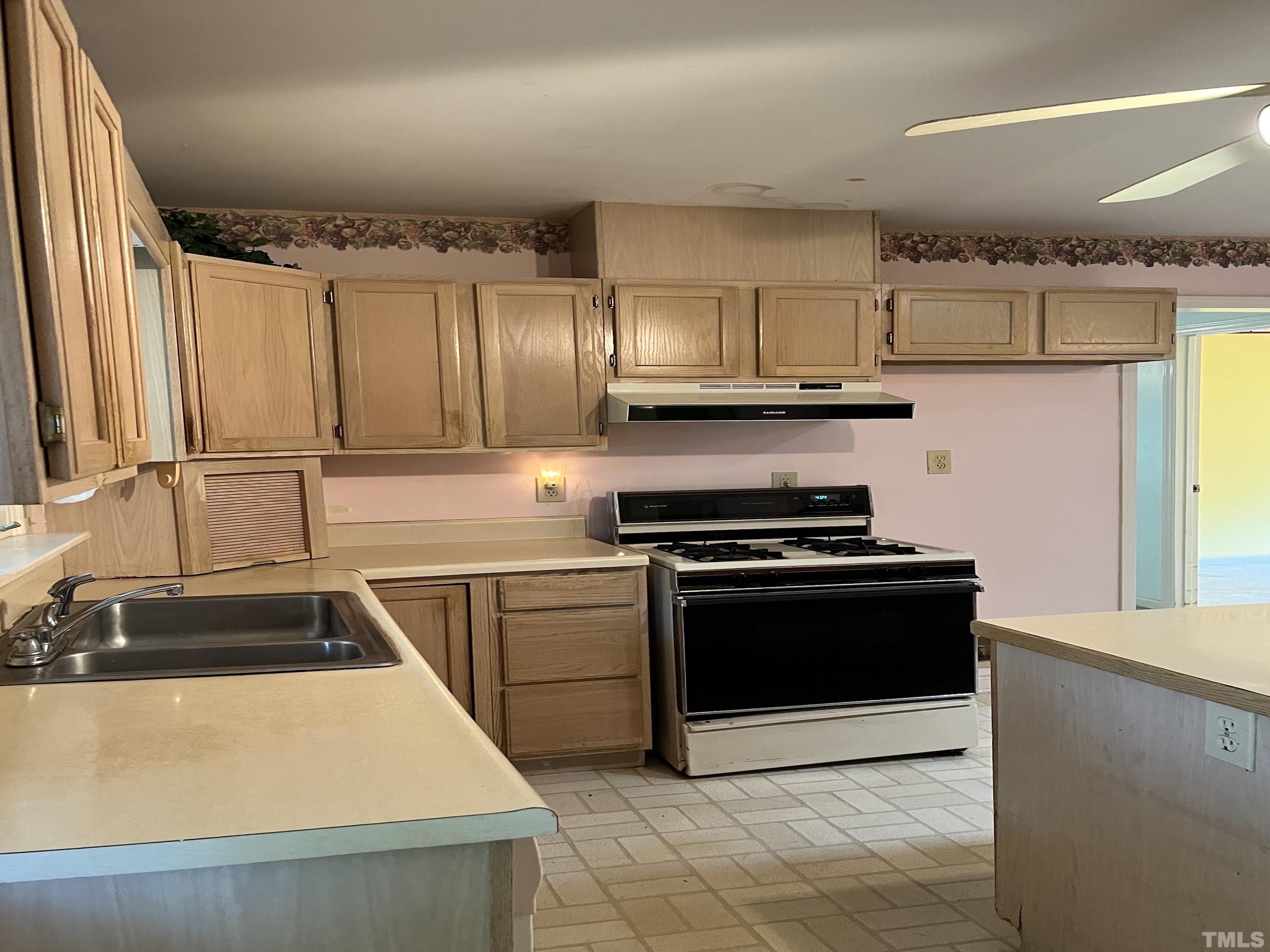 2171 Bud Lipscomb Road Willow Spring, NC 27592 - Photo 13 of 20 a kitchen with kitchen island granite countertop a sink stove and refrigerator