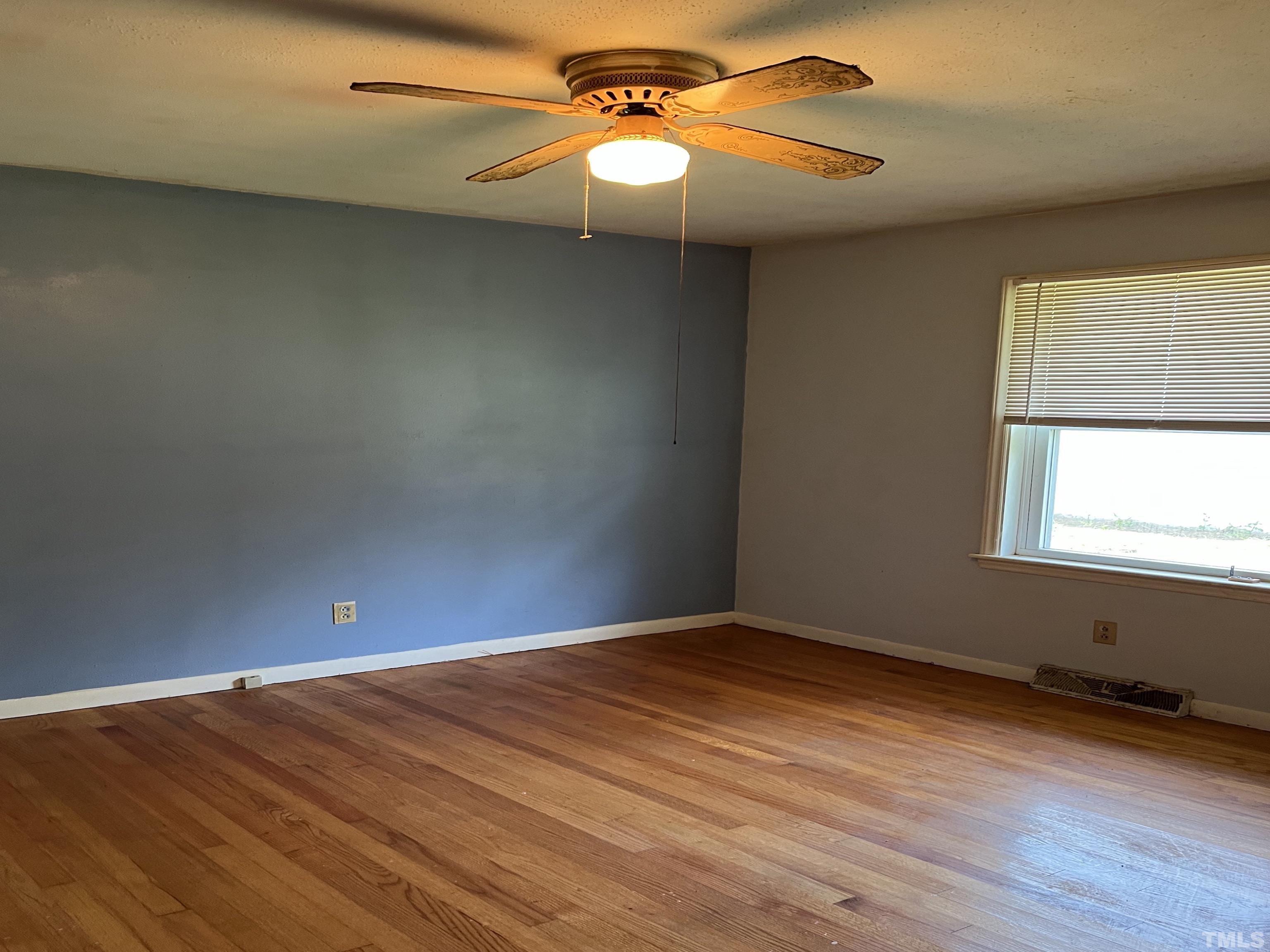 2171 Bud Lipscomb Road Willow Spring, NC 27592 - Photo 14 of 20 a view of empty room with wooden floor and fan