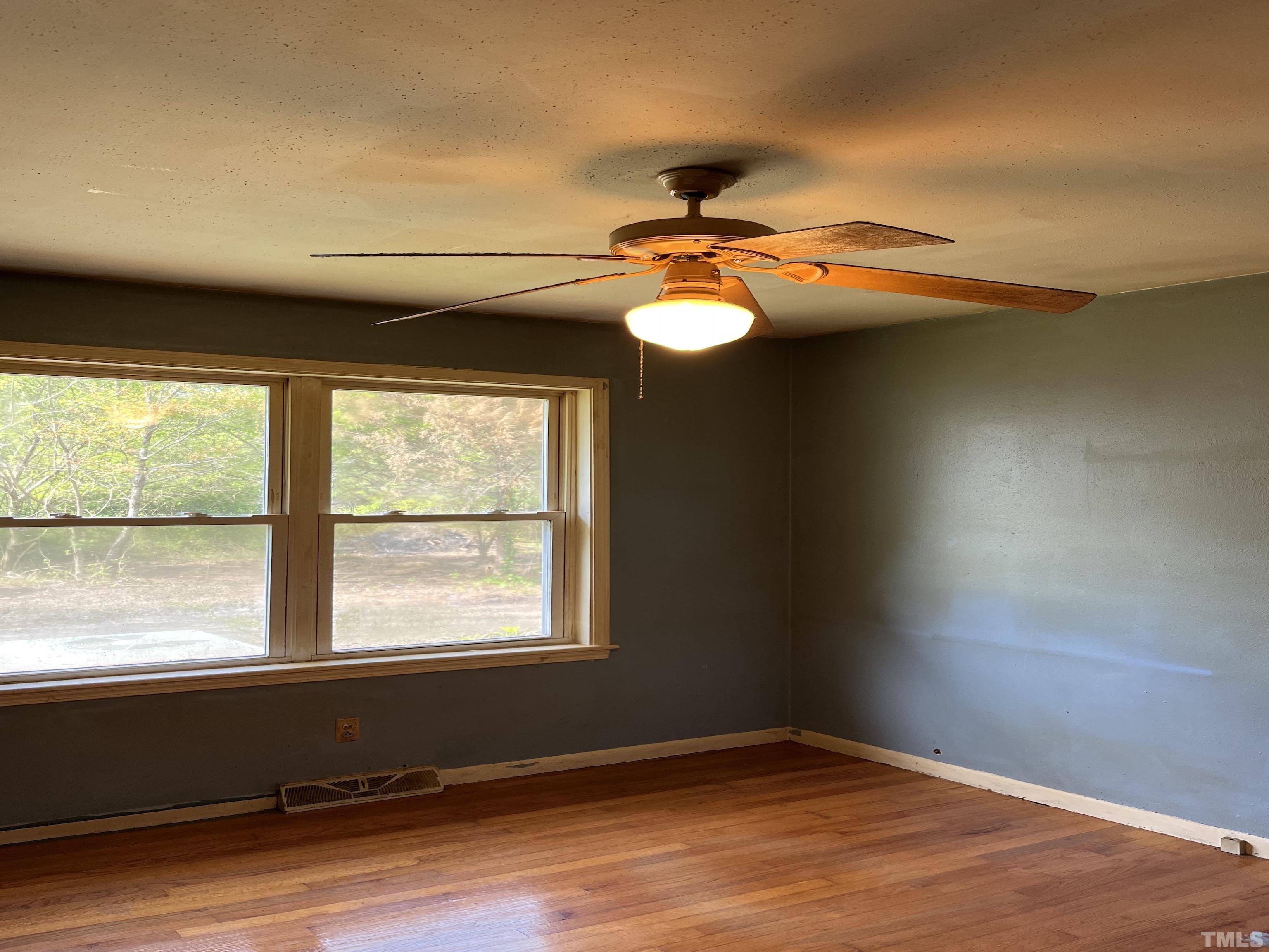 2171 Bud Lipscomb Road Willow Spring, NC 27592 - Photo 15 of 20 an empty room with wooden floor and windows
