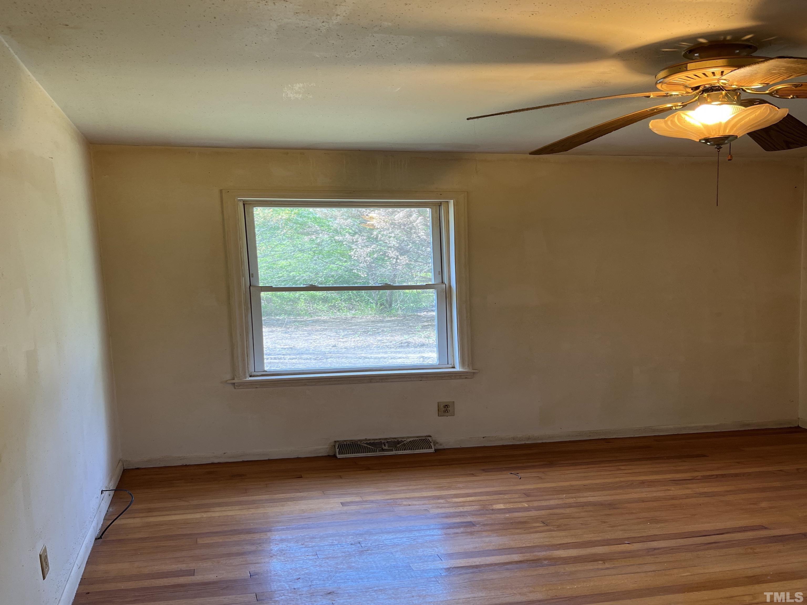 2171 Bud Lipscomb Road Willow Spring, NC 27592 - Photo 16 of 20 an empty room with wooden floor and windows