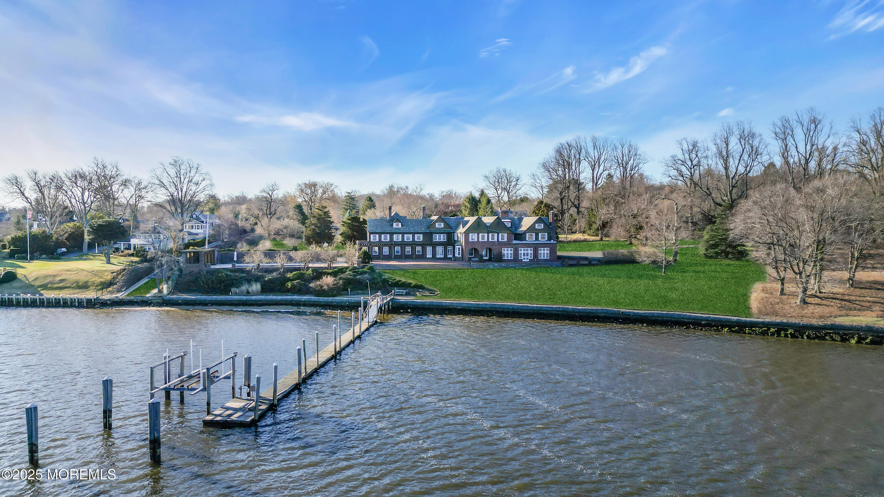 66 A West River Road Rumson, NJ 07760 - Photo 15 of 34 a view of a lake with a bench and trees in the background