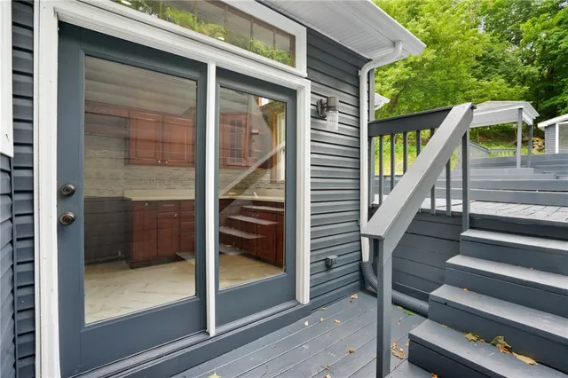 a view of a roof deck with wooden floor and fence next to a yard