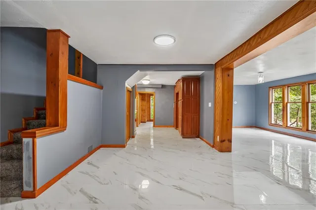 a view of a hallway with windows and chandelier