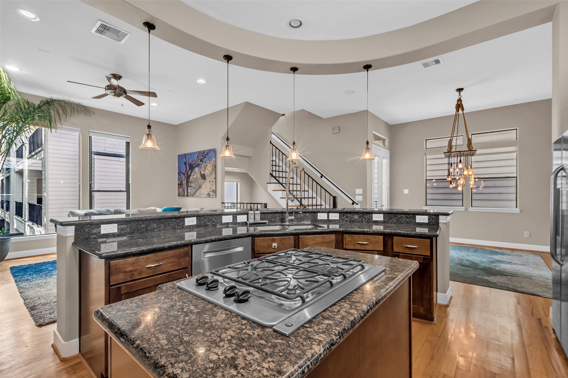 a kitchen with a stove a counter space a large window and furniture