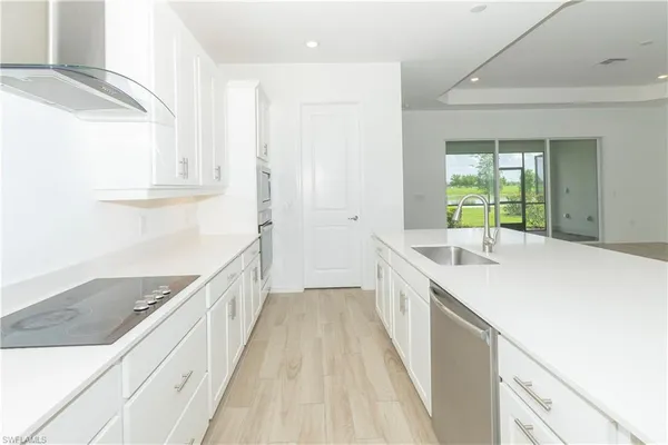a kitchen with a sink and a wooden floor