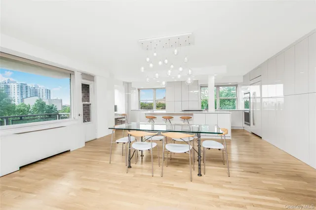 a dining hall with stainless steel appliances a dining table and chairs with wooden floor