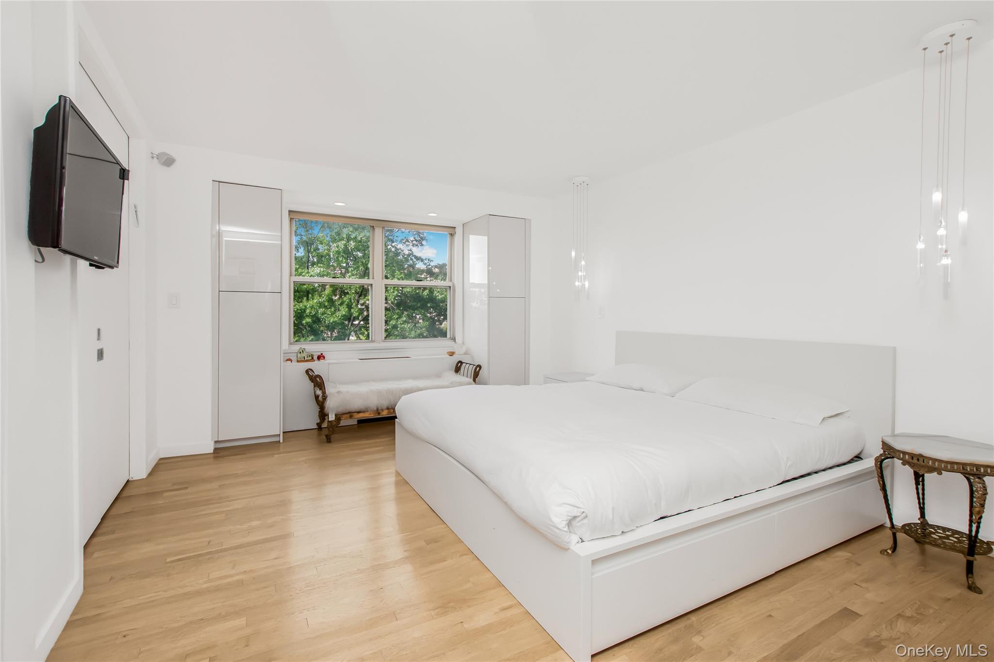 3777 Independence Avenue, Unit 7H Bronx, NY 10463 - Photo 11 of 26 a bedroom with a bed a flat screen tv and window