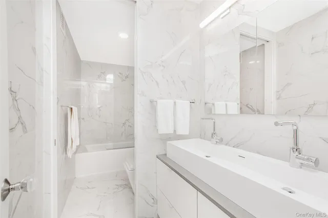 a bathroom with a sink a shower and a mirror