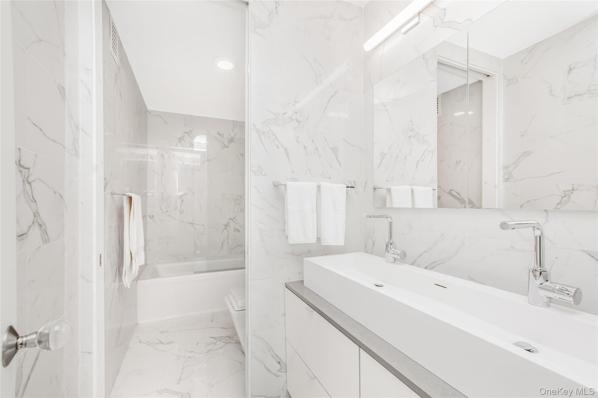 3777 Independence Avenue, Unit 7H Bronx, NY 10463 - Photo 9 of 26 a bathroom with a sink a shower and a mirror