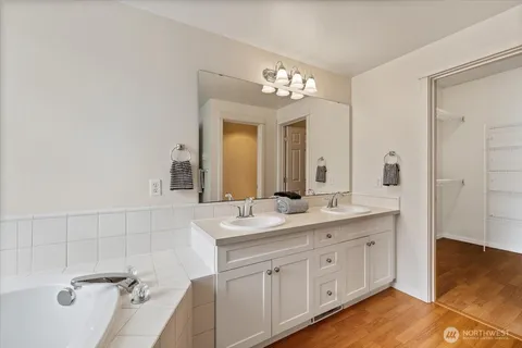 a bathroom with a tub sink and mirror