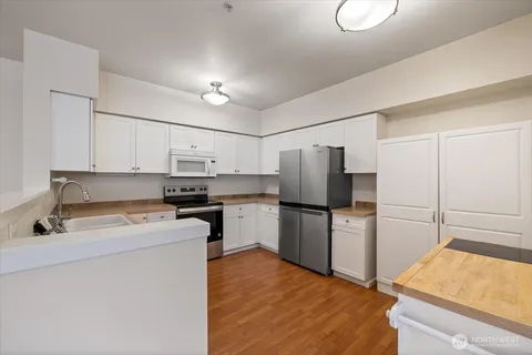 a kitchen with a sink cabinets and wooden floor