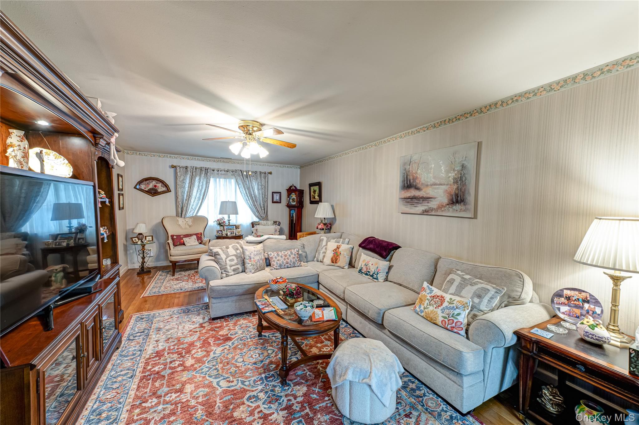 12 Blue Point Road East, Unit 12 Holtsville, NY 11742 - Photo 8 of 20 a living room with furniture a flat screen tv and a lamp
