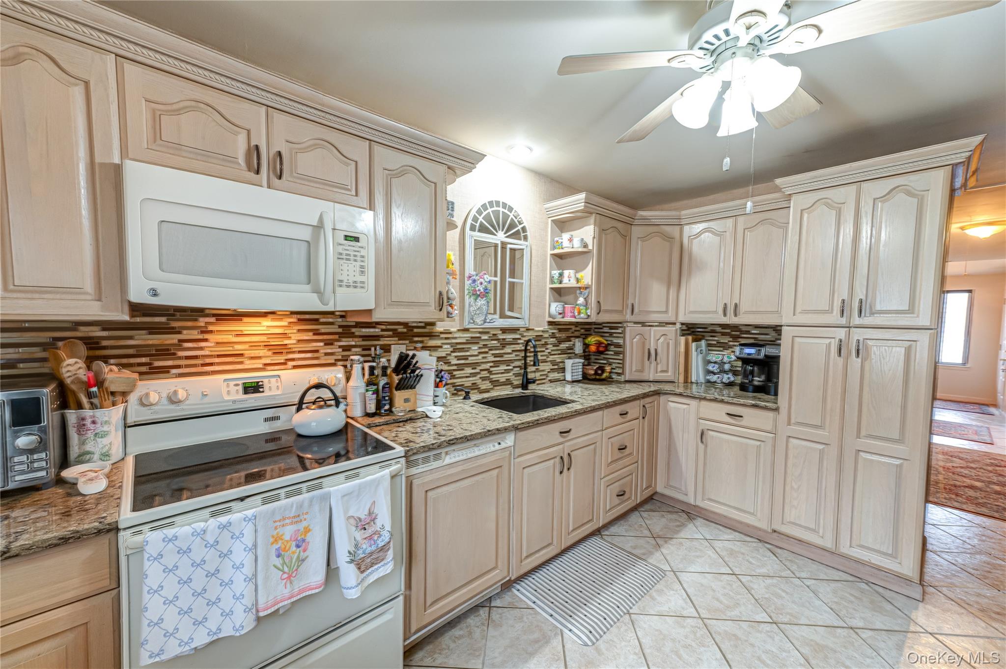 12 Blue Point Road East, Unit 12 Holtsville, NY 11742 - Photo 10 of 20 a kitchen with white cabinets and white appliances