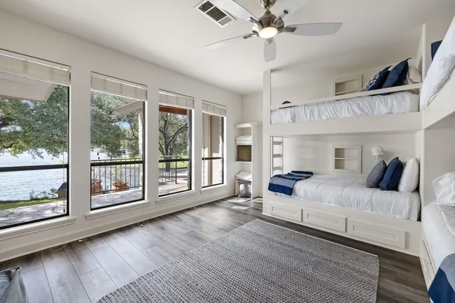 a bedroom with furniture large window and wooden floor