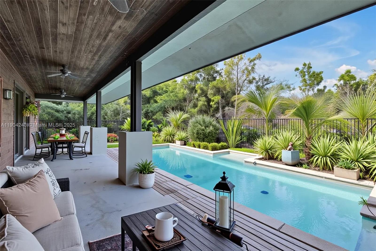 a view of a chairs and table in patio with swimming pool