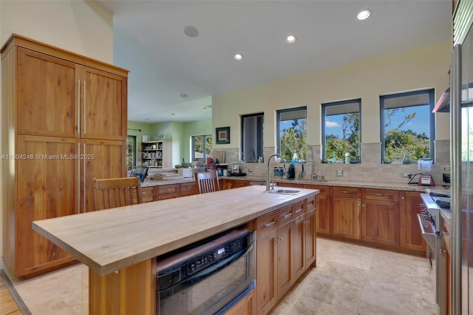 23051 Southwest 153rd Court Miami, FL 33170 - Photo 2 of 33 a kitchen with a stove a sink a microwave a dining table and chairs
