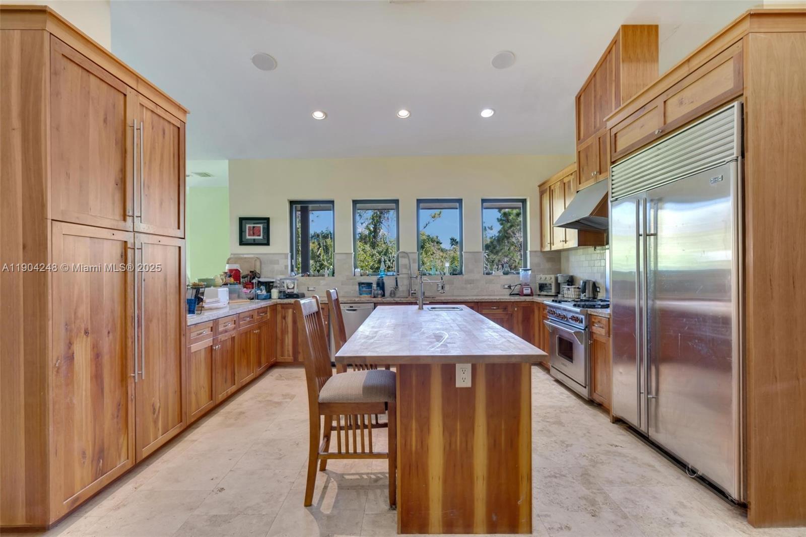 23051 Southwest 153rd Court Miami, FL 33170 - Photo 4 of 33 a kitchen with stainless steel appliances granite countertop a refrigerator a sink dishwasher a stove and a dining table with wooden floor