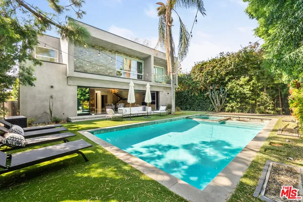 a view of an house with swimming pool and chairs
