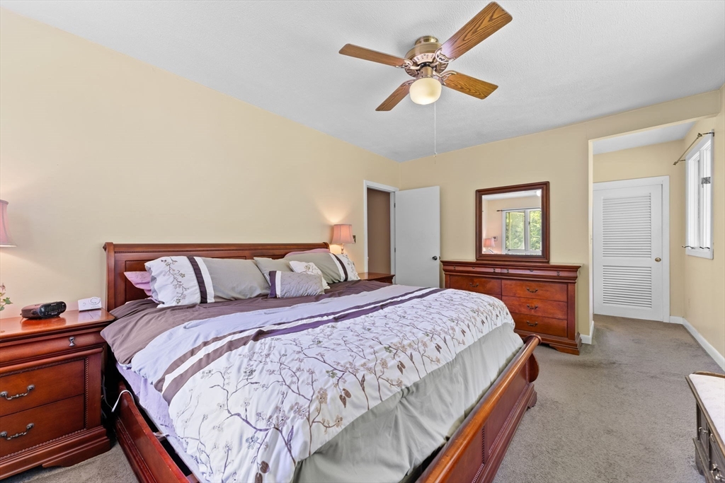 46 Highland Road Boxford, MA 01921 - Photo 20 of 41 a bedroom with a large bed and a chandelier