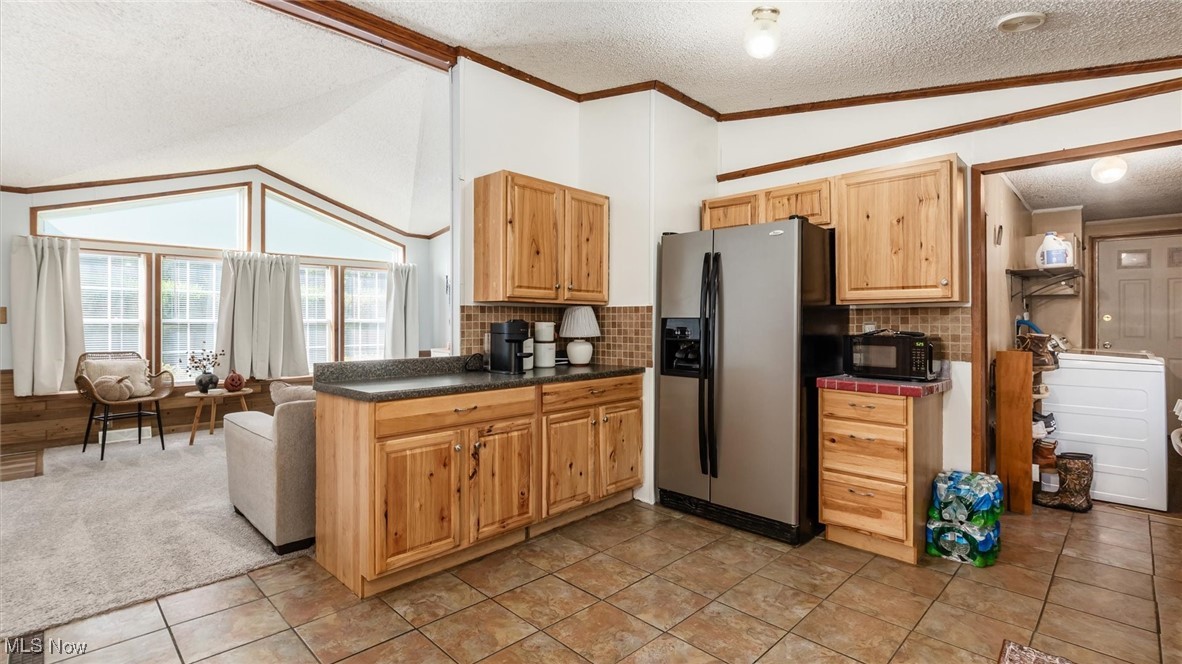 13306 Fairview Road Southeast Newark, OH 43056 - Photo 10 of 48 Kitchen with vaulted ceiling, a textured ceiling, stainless steel fridge, ornamental molding, and backsplash