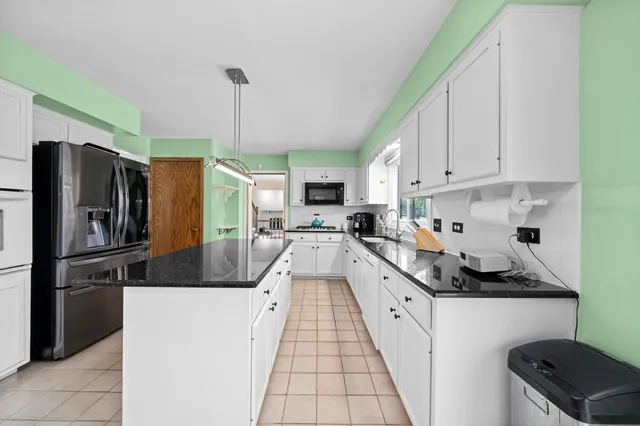 a kitchen with granite countertop a refrigerator a stove and a sink