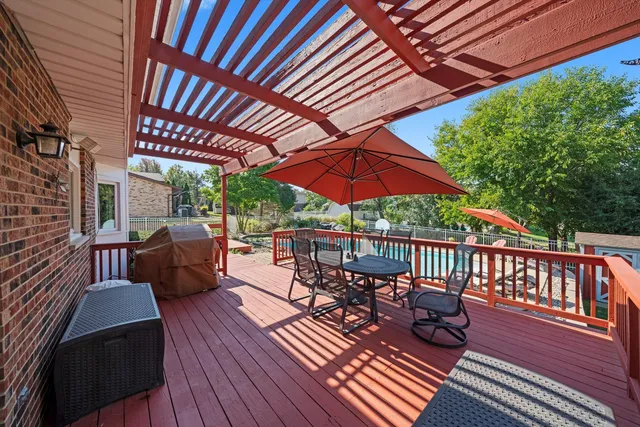 a patio with wooden floor a yard a table and chairs