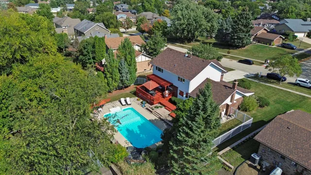 an aerial view of a house with a swimming pool a yard and a garage