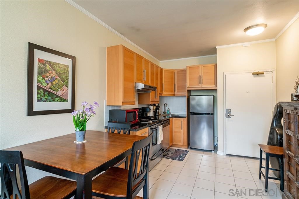 2650 Broadway, Unit 314 San Diego, CA 92102 - Photo 5 of 16 a kitchen with stainless steel appliances a stove a refrigerator a dining table and chairs