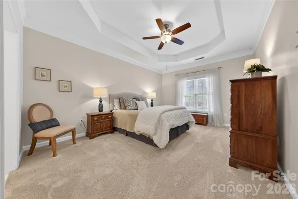 a spacious bedroom with a bed and a chandelier