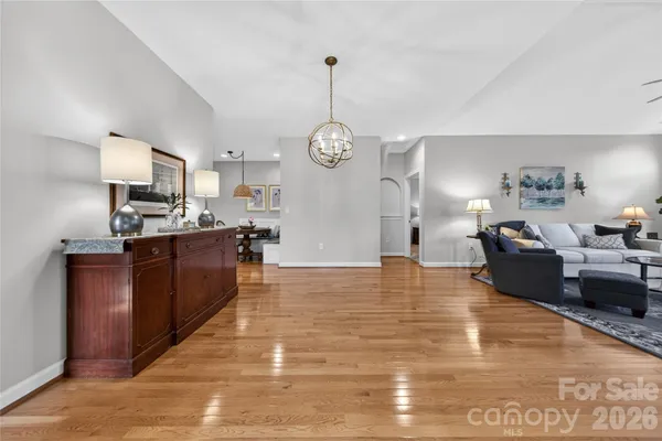 a living room with stainless steel appliances granite countertop furniture and a chandelier