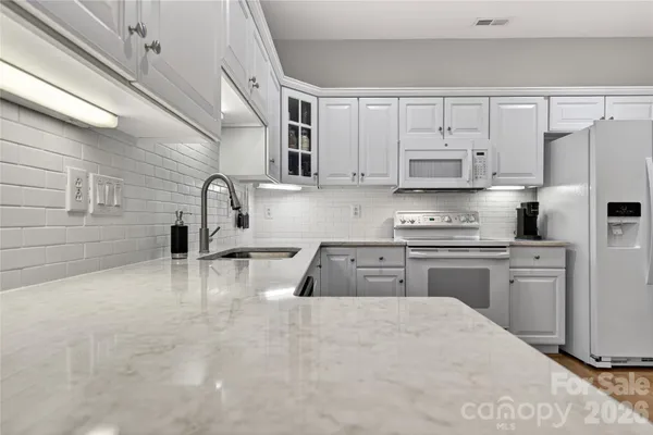 a kitchen with kitchen island a white counter top space cabinets and stainless steel appliances