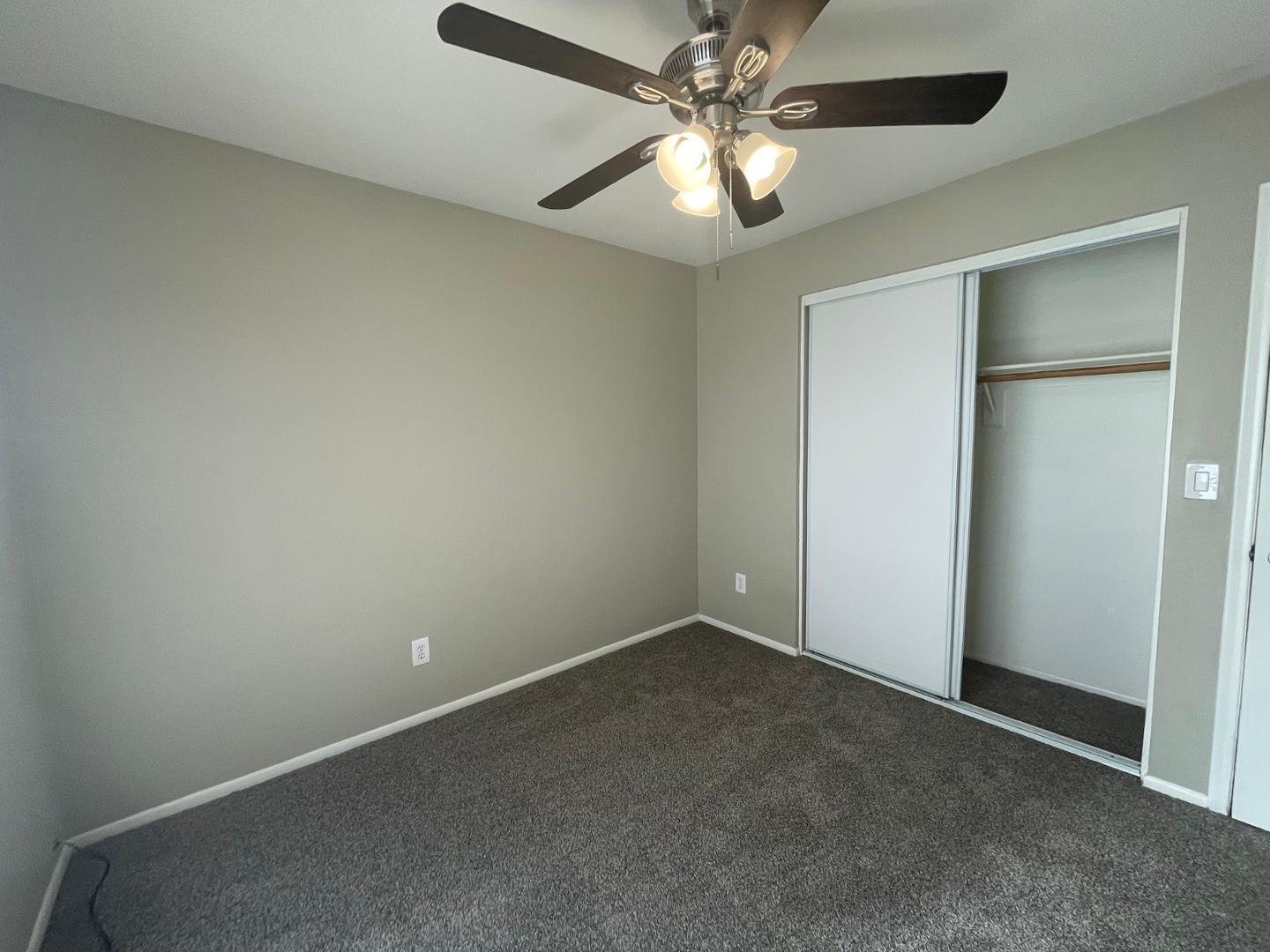 10902 West Montecito Avenue Phoenix, AZ 85037 - Photo 17 of 22 an empty room with a chandelier fan and windows