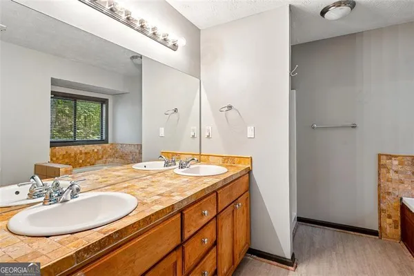 a bathroom with a granite countertop sink and a mirror