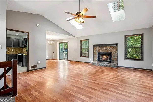 a view of an empty room with window and wooden floor