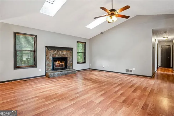 an empty room with windows and a fireplace