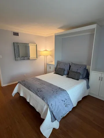 a bedroom with a bed and wooden floor