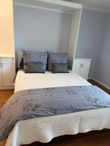 a large bed sitting in a bedroom next to a window