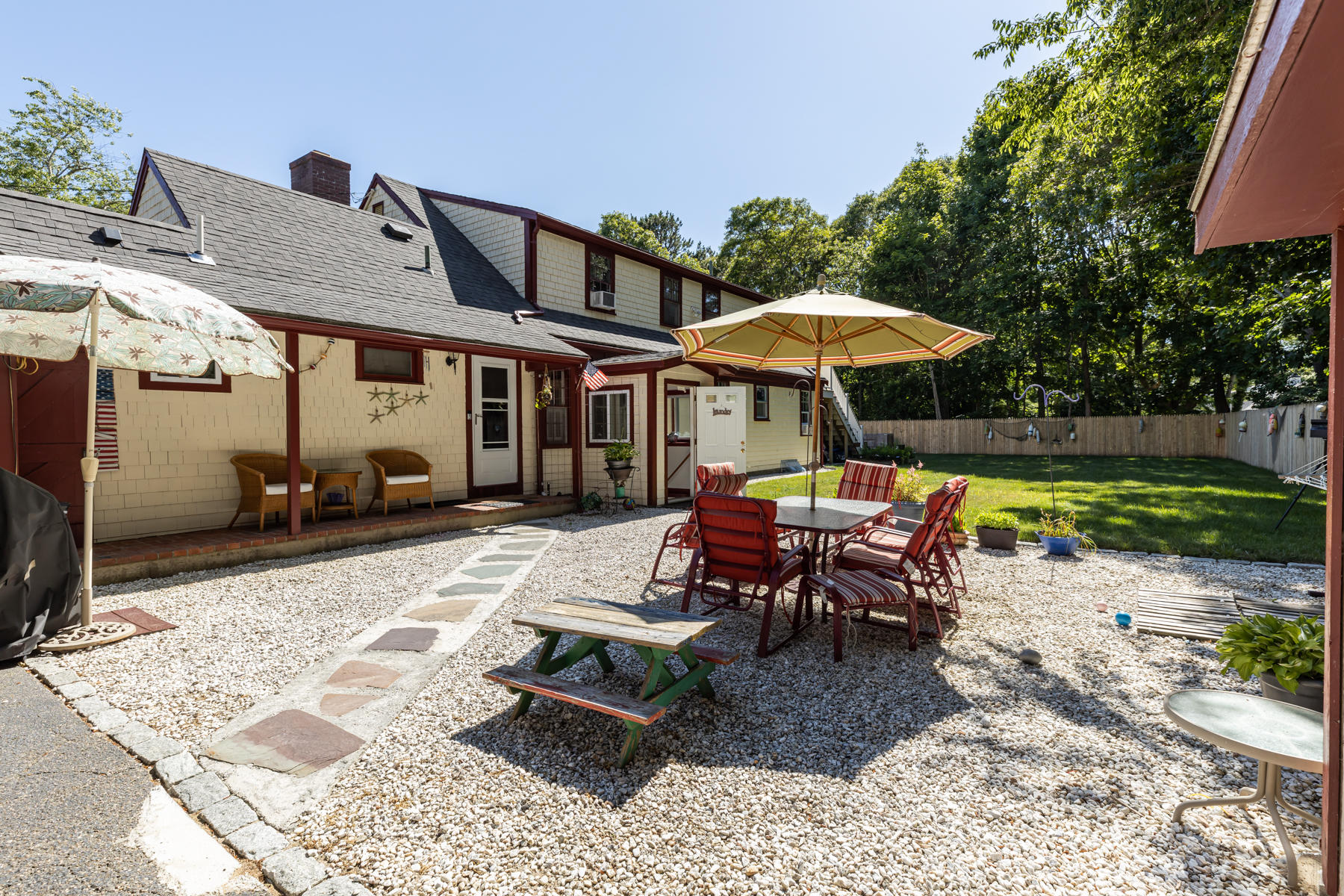 64 Murphy Road Hyannis, MA 02601 - Photo 4 of 64 a view of a patio with a dining table and chairs under an umbrella