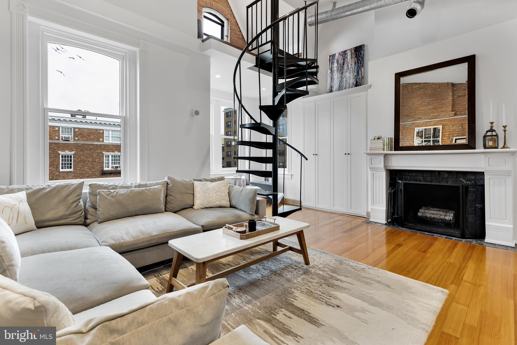 a living room with furniture a fireplace and a window