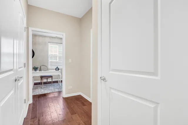 a view of a hallway with wooden floor and a living room