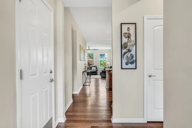 a view of a hallway with wooden floor and a living room